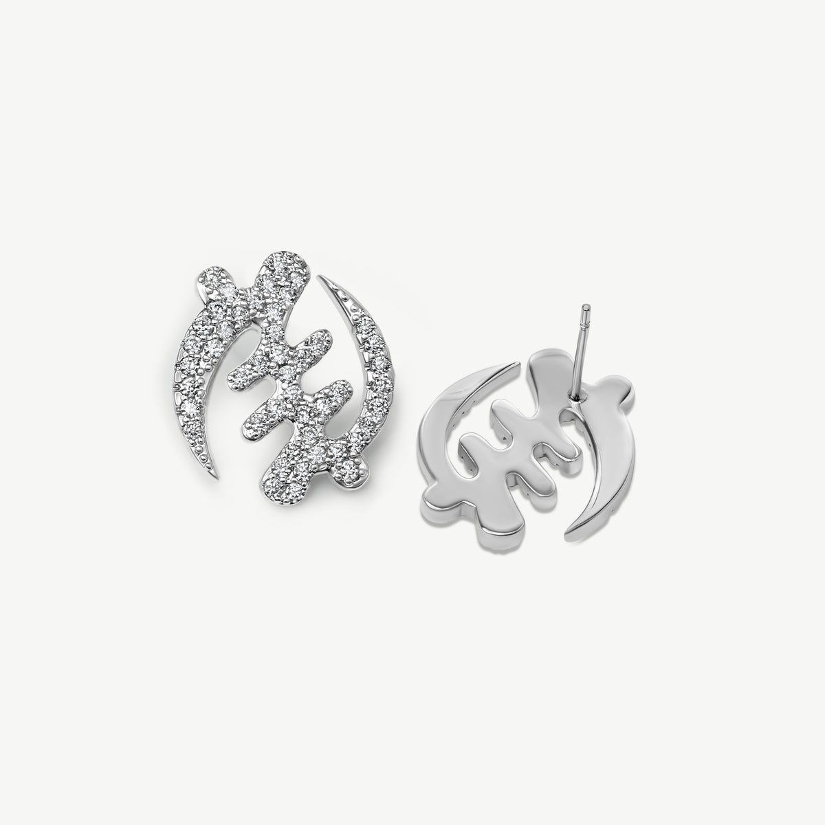 Pair of silver Gye Nyame Adinkra symbol stud earrings, one showing the front with pavé-set high-grade zircon stones and one showing the smooth gold back and post.