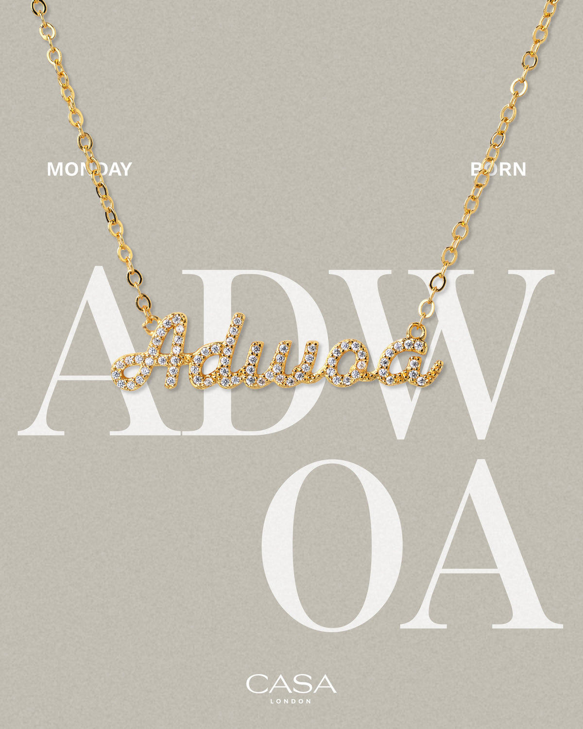 A product shot of CASA London’s 18k gold Adwoa Pavé Necklace. The delicate gold chain features a script pendant spelling "Adwoa," encrusted with shimmering pavé-set stones against a neutral, textured background. Overlaid text reads "MONDAY BORN," highlighting the brand's commitment to celebrating cultural heritage and personal narratives through modern luxury.