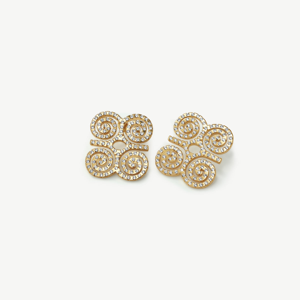 A high-resolution product shot of CASA London's 18k gold plated Dwennimmen Pavé Stud Earrings. The pair features the intricate Adinkra symbol of rams' horns, representing strength and humility, meticulously encrusted with shimmering pavé-set stones. Set against a minimalist white background, the design highlights the brand's commitment to merging historic West African artistry with sophisticated, modern luxury.