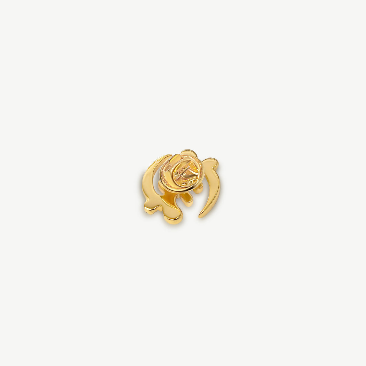 A rear product shot of CASA London's 18k gold plated Gye Nyame lapel pin. The pin is meticulously shaped into the iconic Adinkra symbol and encrusted with shimmering pavé-set stones. This display highlights the brand's commitment to superior craftsmanship and the fusion of cultural heritage with modern luxury.