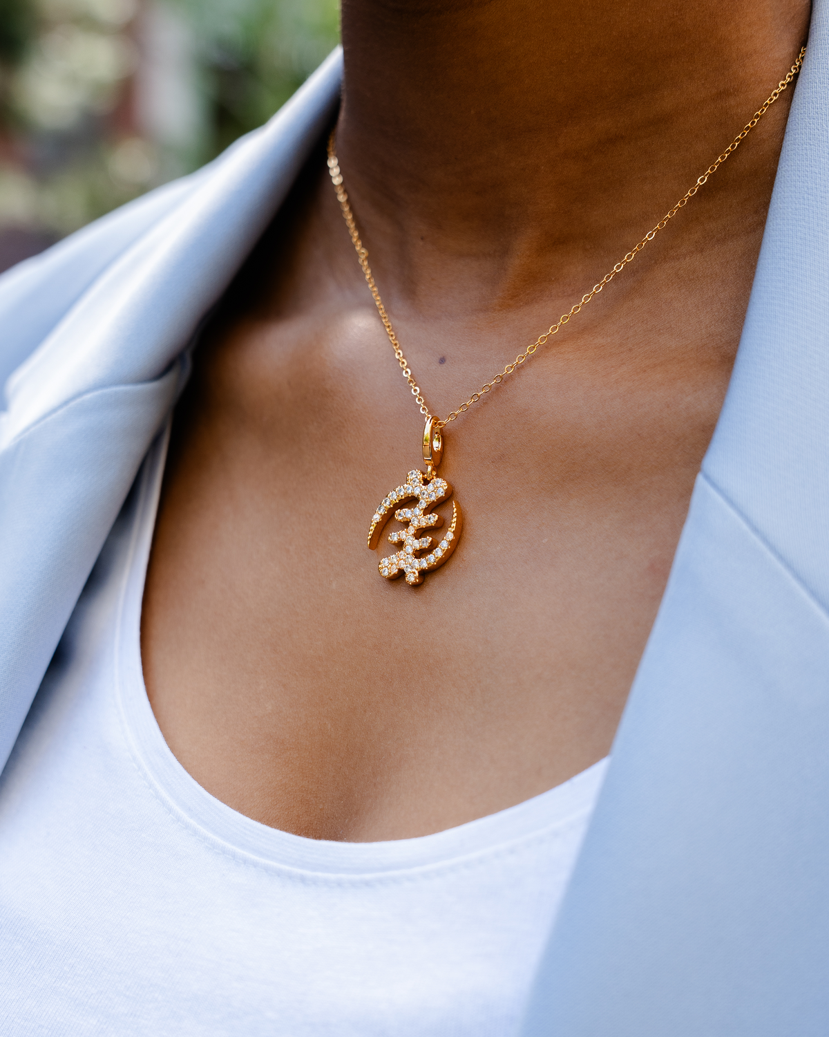 CASA LONDON Gye Nyame Pendant in 18ct gold plated. Symbolizing the 'Supremacy of God', this pendant also adds cultural significance to your look, versatile and timeless, pair it with a chain or bracelet for a complete look.