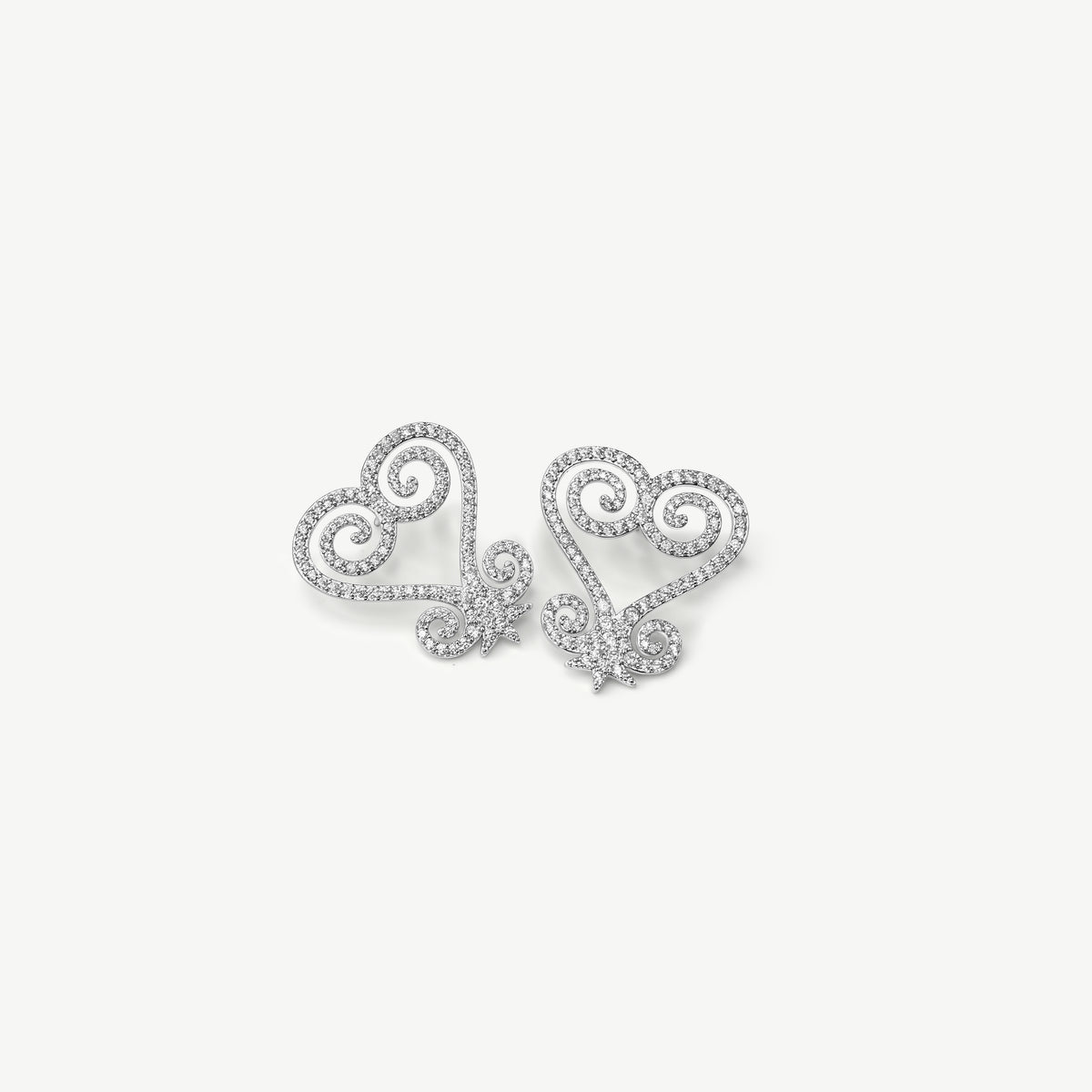 A product shot of CASA London's silver Sankofa Pavé earrings displayed on a clean white background. One earring is shown from the front and the other from the back, highlighting the intricate heart-shaped Sankofa Adinkra symbol meticulously encrusted with shimmering pavé-set stones. This display showcases the brand's unwavering commitment to superior craftsmanship and modern luxury design.