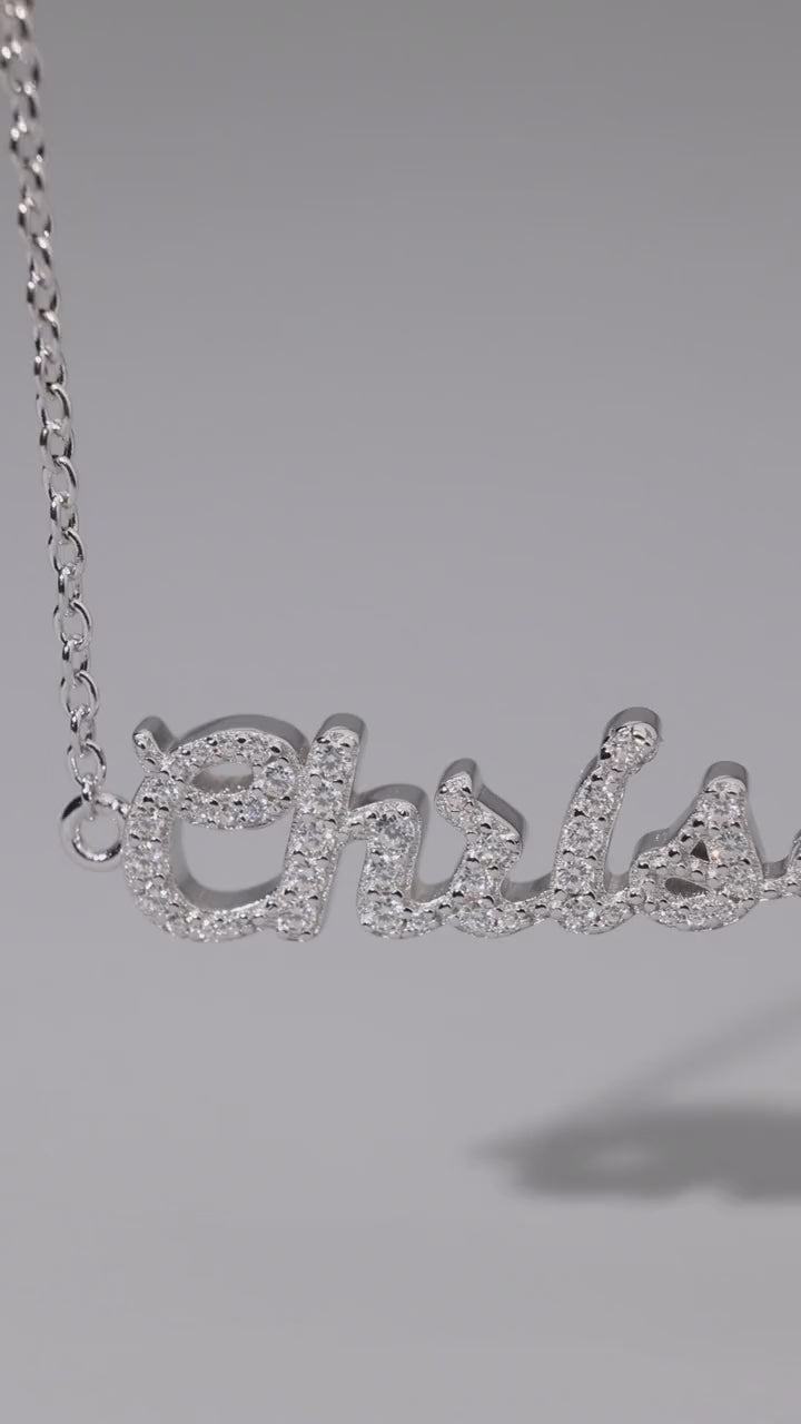 CASA London bespoke pavé name necklace in rhodium-plated silver, set with moissanite stones, hanging on a silver chain