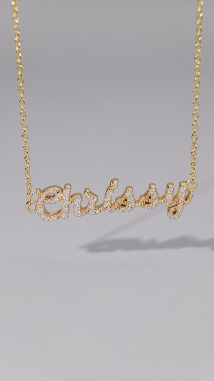 CASA London bespoke pavé name necklace in 18k gold vermeil, set with moissanite stones, hanging on a gold chain
